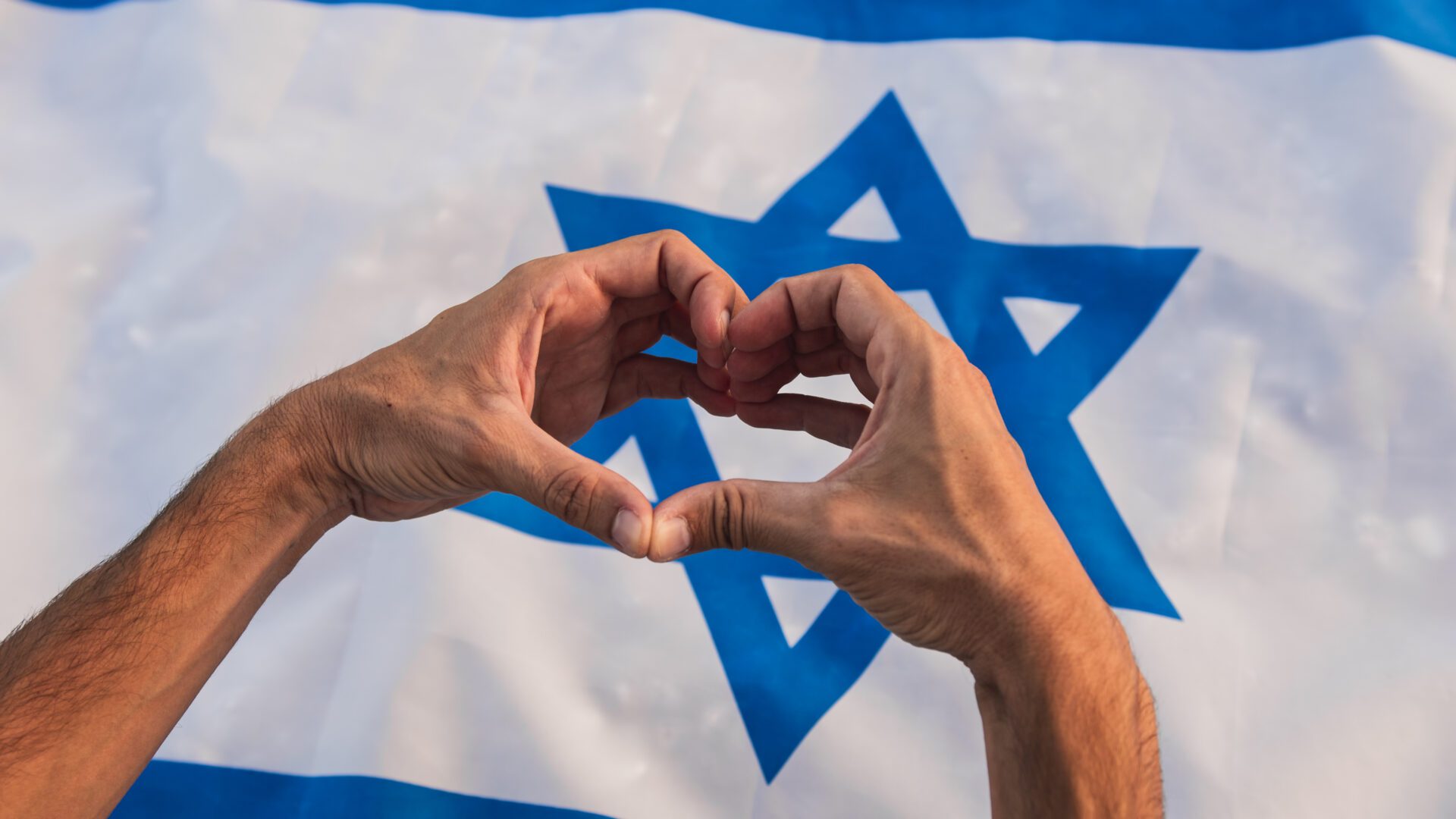 Hand in heart shape on Israel flag Shalom Act